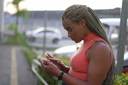 A black woman looks at her phone